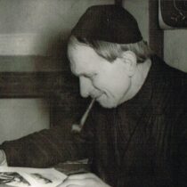 Wiktor Stachowiak z fajką pochylony nad dokumentami